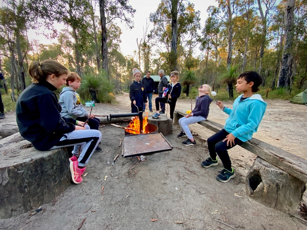 Bibbulmun Track walkers gathered around a campfire